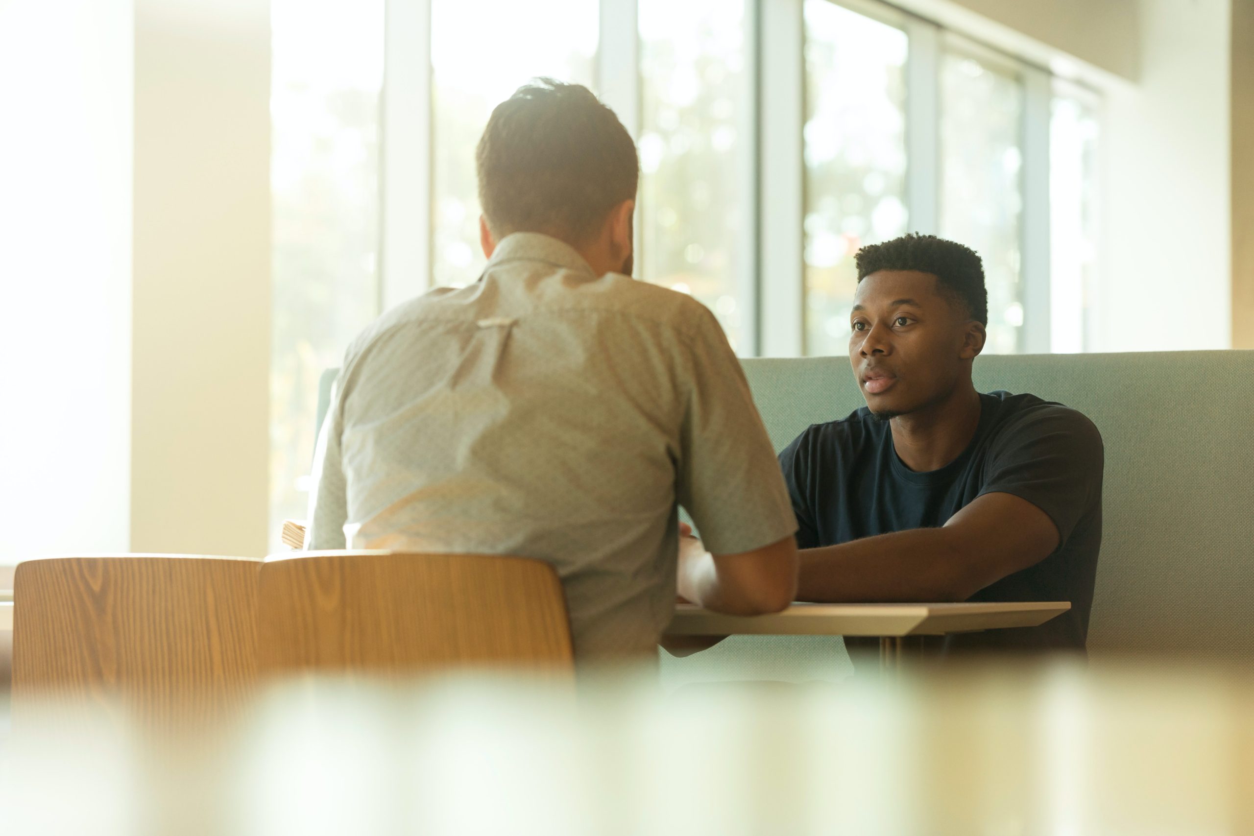 two people sitting down talking together