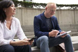 Man and woman discussing with notebook